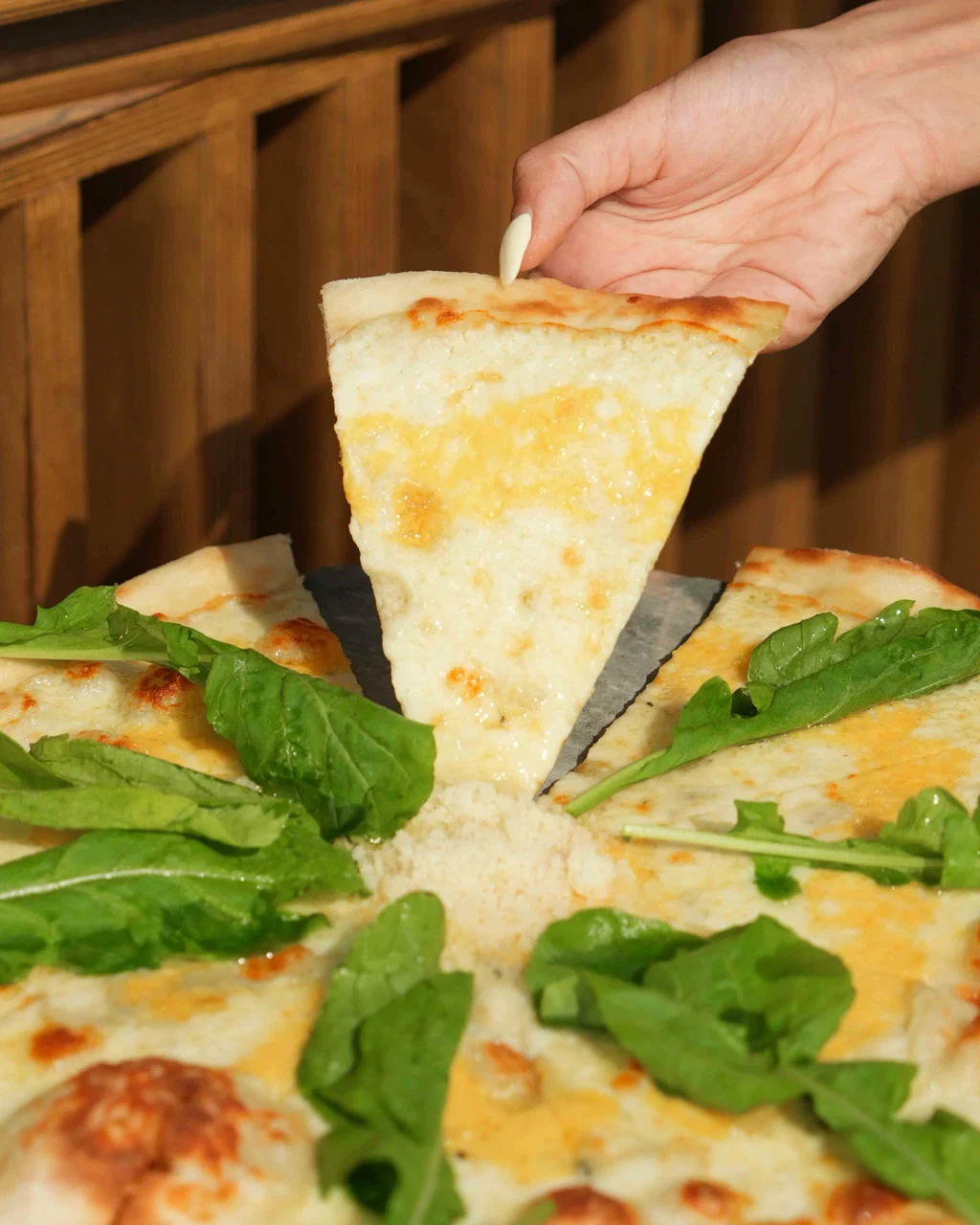 Roka ile servis edilen peynirli pizza dilimi