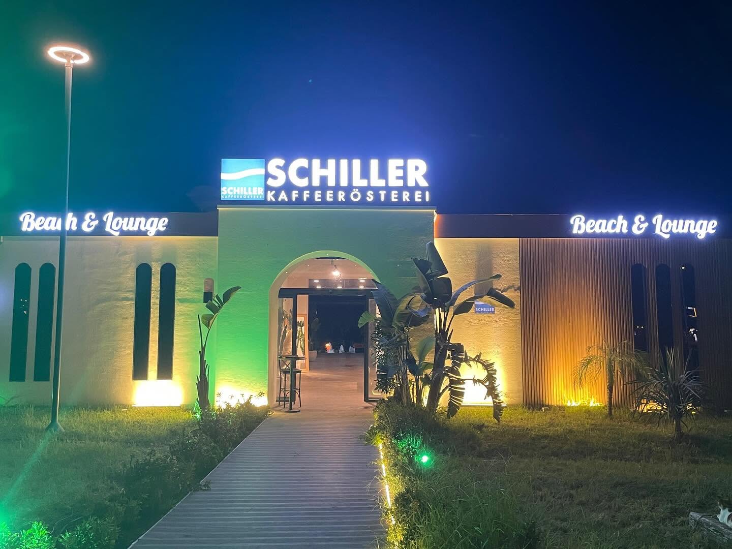 Gece ışıklandırılmış Schiller Kaffeerösterei Beach & Lounge girişi